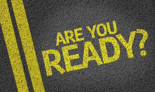 The phrase "ARE YOU READY?" in bold yellow lettering on a textured black surface with yellow lines.